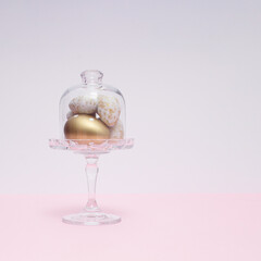 Golden Easter eggs in a cake holder. Easter holiday concept with copy space.