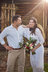 bride in cowboy style sits on threshold of hayloft