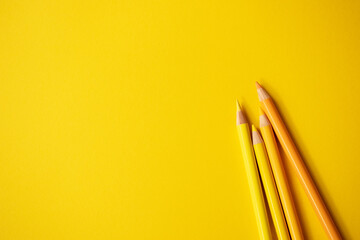 Gelbe Buntstifte auf gelbem Hintergrund. Freiraum für Text