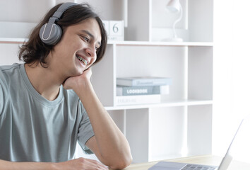 Naklejka premium Young Asian men are greeting friends and teachers through video chats and greeting them with cheerful expressions, Online communication , Stay home, New normal, Social distancing, Internet learning.