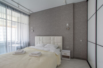 Master bedroom with sliding wardrobe and balcony door. Elegant and comfortable hotel bedroom...