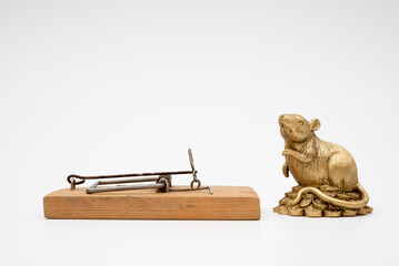 figurine of a mouse near a mousetrap on a white background