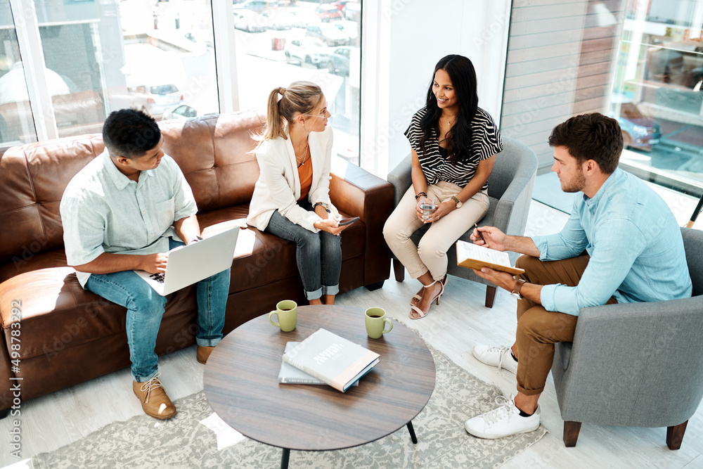 Poster building on top of each others ideas. shot of a group of businesspeople having a discussion in an of