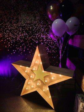 wooden star with light bulbs at the party