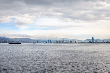 Naklejka premium City view of Izmir from ferryboat. Cold grey winter Aegean sea.