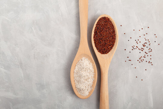 Coarse flour Ragi and red quinoa grain in wooden spoons on grey background. Gluten free healthy food