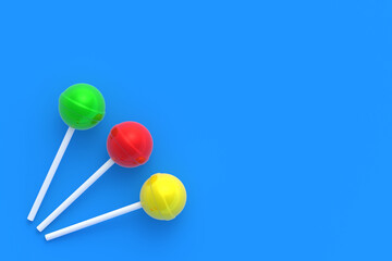 Colorful lollipops on stick on blue background. Sweet candy. Confectionery goods. Top view. Copy space. 3d render