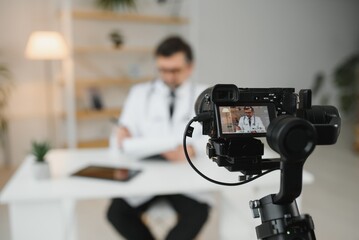 Handsome male doctor recording video for medical blog - obrazy, fototapety, plakaty