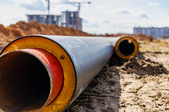 Insulated pipe. Large metal pipes with a plastic sheath laid in a trench. Modern pipeline for supplying hot water and heating to a residential area.