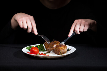 Fresh steak with vegetables and spices on a white plate and black background.