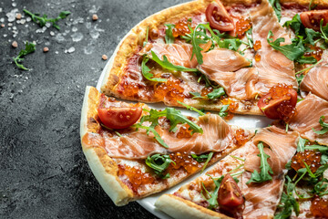 Delicious hot pizza with salmon, red caviar, tomatoes and aragula ready to eat. banner, menu, recipe place for text, top view