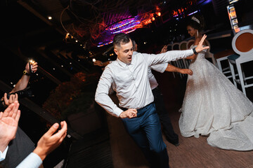 Traditional folk dance. Loving couple at an international wedding at sunset. Beautiful...