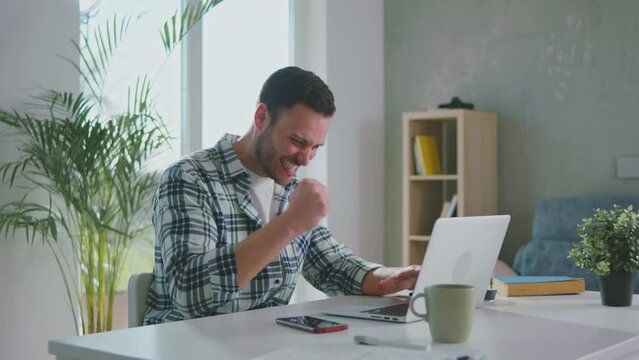 Handsome  businessman is chilling and enjoying his success while looking at laptop