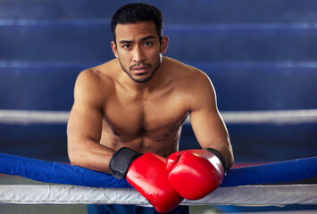 Another fight finished. Cropped portrait of a handsome young male boxer leaning against the ropes after a fight in the ring.