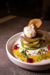 Plate with green pancakes and berry jam