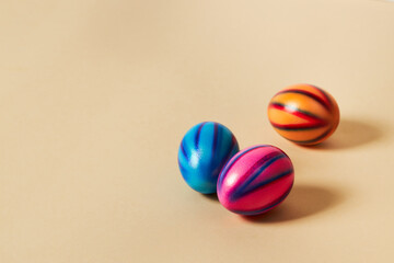 Obraz premium Colorful Easter eggs with on a solid beige background. Preparation for holiday.