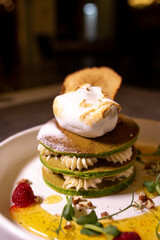 stack of green pancakes with cream close-up