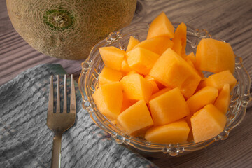 Muskmelon fruit cut into cubes which is rich in vitamins and minerals. Top view of bowl of...