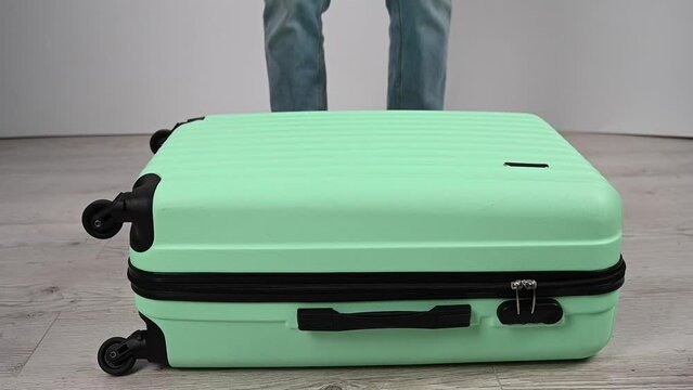 A woman does a crash test of a plastic suitcase. Slow motion. 
