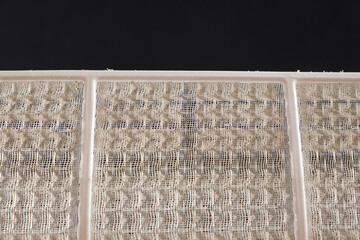 Dusty air conditioner filter. A lot of dust on the net, asthma and allergy to dust, cleaning of filters