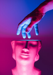 Hand reaching inside the marble sculpture head with neon led illumination. Futuristic, cyberpunk...