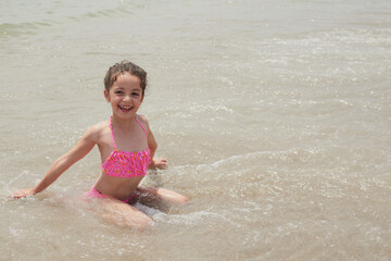 Girl playing happily on the shore of the beach, Vera, Spain