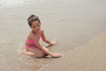 Girl playing happily on the shore of the beach, Vera, Spain