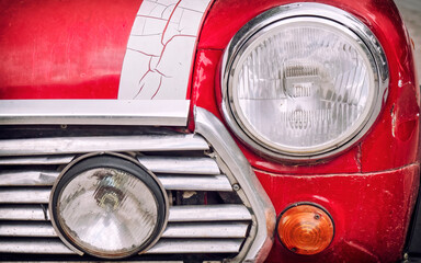 A classic sixties red white British racing car's headlight closeup