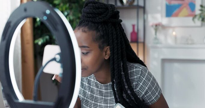 A makeup influencer advertises a product from a well-known cosmetics brand. The woman hosts a live beauty with a paid collaboration. The girl presents an eyeshadow palette.