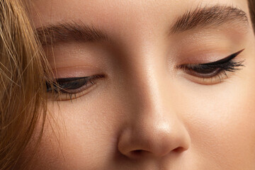 Beautiful macro shot of female eye with classic smoky makeup. Perfect shape of eyebrows, brown eyeshadows and long eyelashes.Closeup macro shot of fashion smoky eyes visage. Before and after