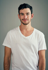 Casually handsome. Studio shot of a casual young man posing against a grey background.
