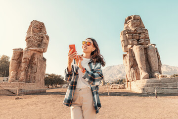 A girl with a smartphone in her hands uses an app or social networks via Wi-Fi Internet standing in...