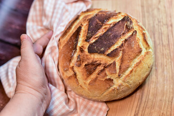 hand holding a loaf of bread