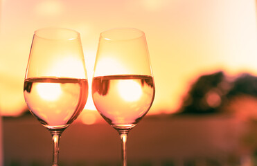 two glasses of wine on sunset background. 