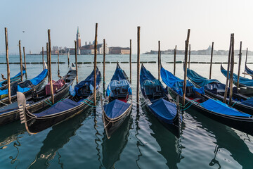 Obraz na płótnie Canvas gondolas parked by the grand canal in Venice, Italy with the church of Saint Giorgio Maggiore in the background