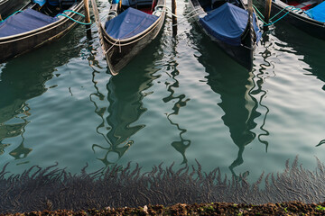 gondolas parked by the grand canal in Venice, Italy with the church of Saint Giorgio Maggiore in the background