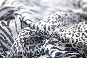 Satin fabric close up background and texture with place for text. Gray leopard print chiffon or silk material.