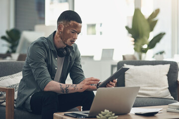 Dont be distracted by criticism. Shot of a young business man using a tablet at work.