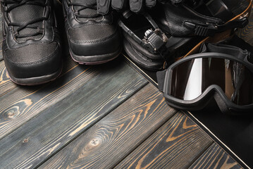 Fototapeta na wymiar Snowboarding equipment on the wooden floor background close up.