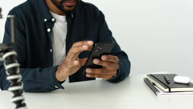 Close up of african male hands holding smartphone. Happy mixed race person enjoy online chat, internet purchase, browse web, download new cool freeware application. Modern wireless tech user concept 