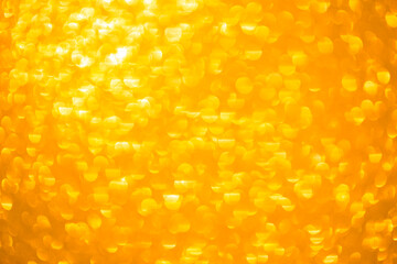 Background texture of shiny golden bokeh. Beautiful festive christmas background for greeting design. Nacreous sparkling yellow texture.