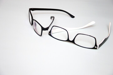 Two glasses in white and black plastic rectangular frames on a white background. Optics. Accessories for vision.