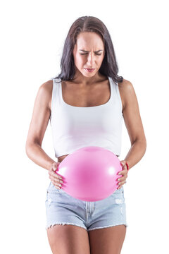 Young woman holding a big pink balloon as a sign of an stomach inflation. Isolated background