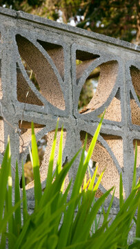 Celosía de bloques de hormigón con dibujo geométrico en jardín
