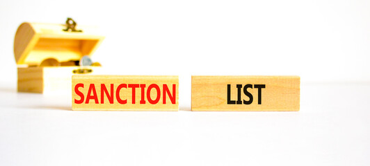 Sanction list symbol. Wooden blocks with concept words Sanction list on beautiful white background. Wooden chest with coins. Business political sanction list concept. Copy space.