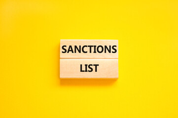 Sanctions list symbol. Wooden blocks with concept words Sanctions list on beautiful yellow...