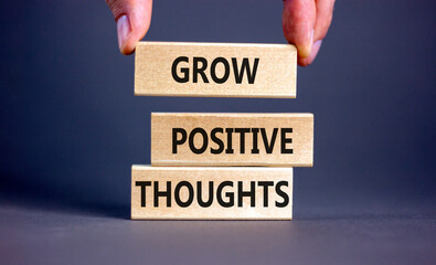 Grow positive thoughts symbol. Concept words Grow positive thoughts on blocks. Businessman hand....