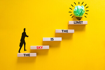 Sky is limit symbol. Concept words The sky is the limit on wooden blocks. Businessman icon. Beautiful yellow table yellow background. Business motivational stress spice of life concept. Copy space.