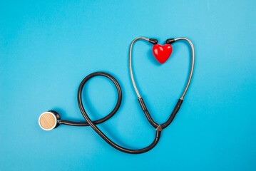 medical stethoscope and small red heart isolated on blue