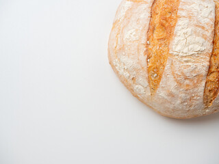A close-up of a whole fresh crispy delicious round-shaped wheat bread on a white background. Insulated items, baking, top vew, flat lay, copy space